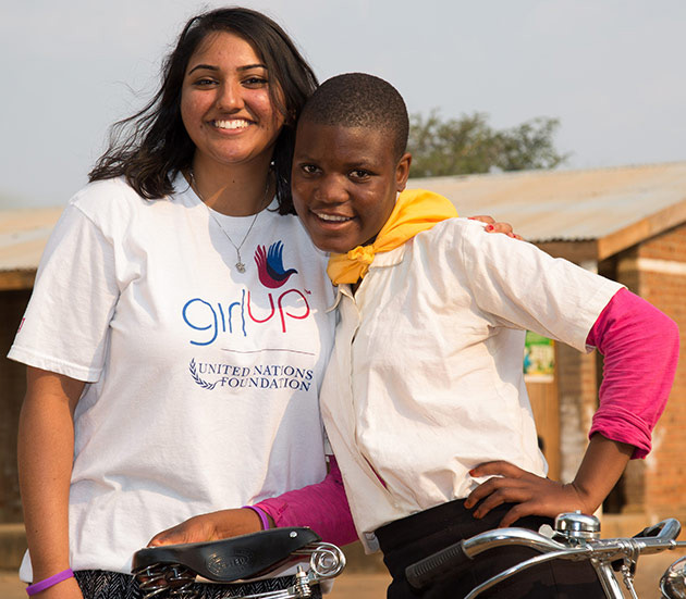 United Nations Girl Up girls smiling with a bicycle