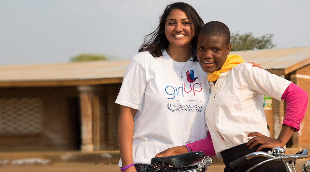 United Nations Girl Up girls smiling with a bicycle