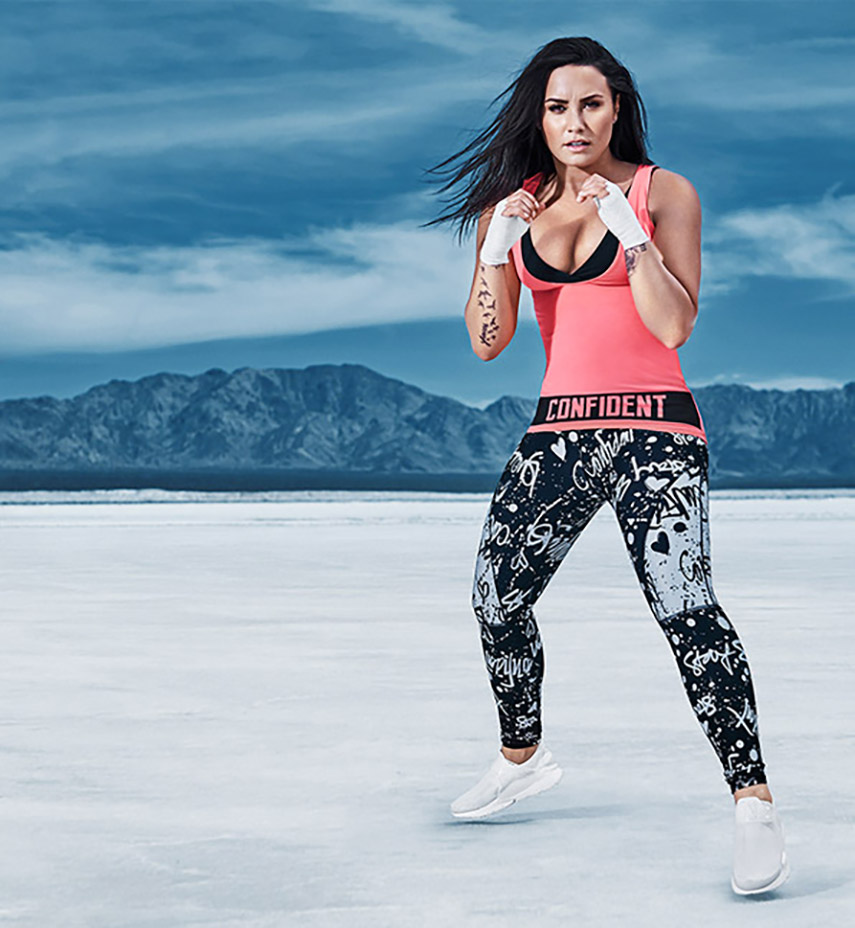 Demi Lovato in the desert wearing a pink and black Fabletics outfit